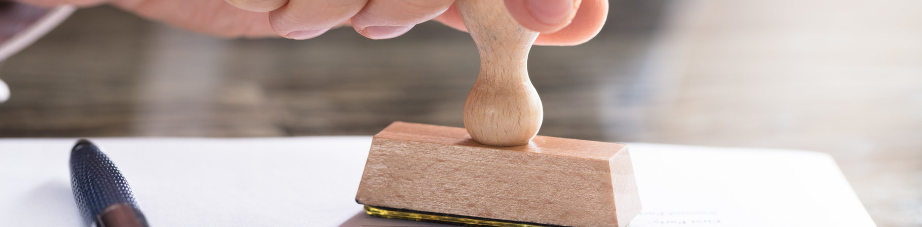 Hand stamping a certifcation onto a piece of paper