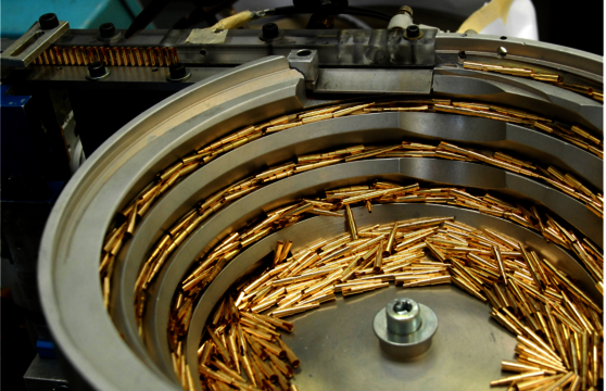 Collection of golden contacts being sorted in a circular sorting machine