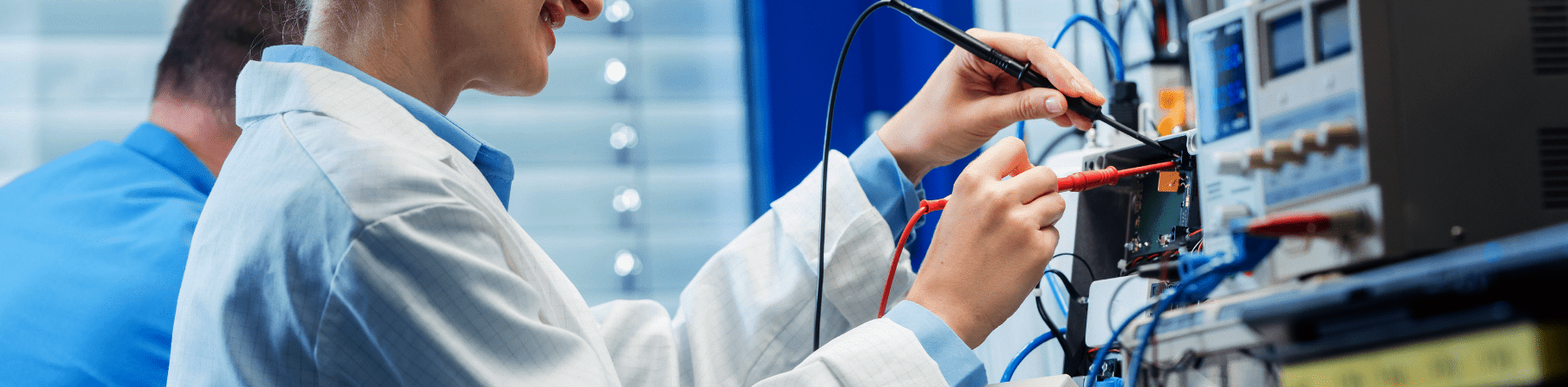 Engineer in a white coat testing and measuring various electrical devices