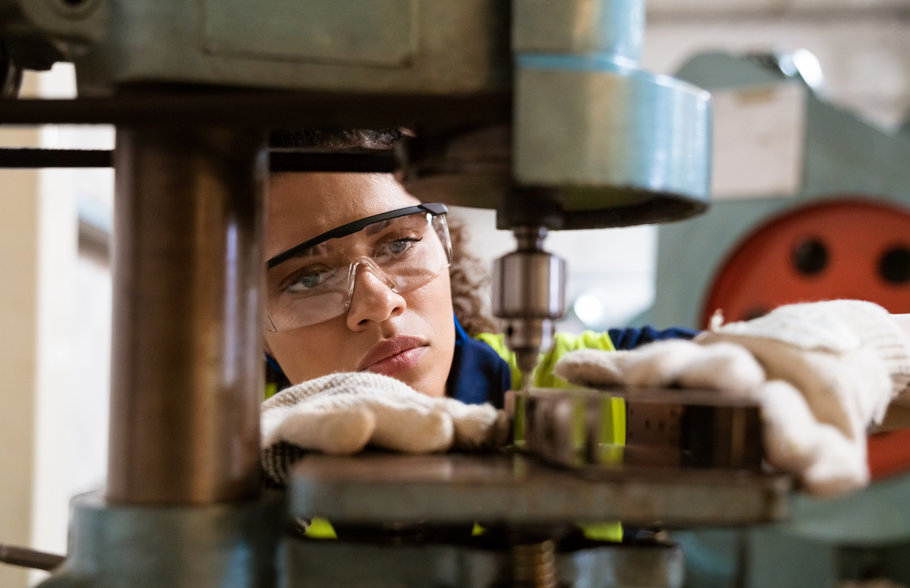 Woman wearing safety gear and using a precision drill