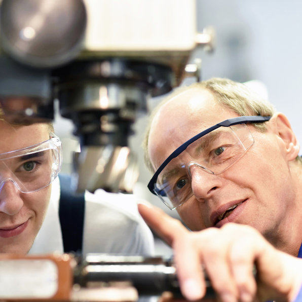 Apprenti CFC apprenant à faire le contrôle de qualité sur des machines à vis de haute précision pour les contacts chez Lemco Précision SA