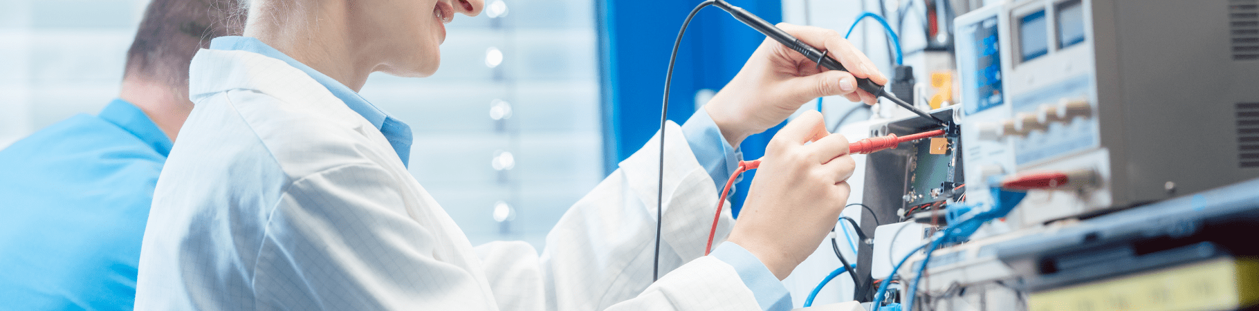 Engineer in a white coat testing and measuring various electrical devices